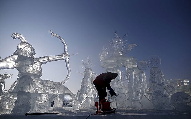 চীনের হেইলংজিয়ান প্রদেশে অনুষ্ঠেয় হারবিন ইন্টারন্যাশনাল আইস অ্যান্ড স্নো ফেস্টিভ্যাল উপলক্ষে বরফের ভাস্কর্য তৈরি করছেন একজন শিল্পী। ছবিটি আজকের। ছবি: রয়টার্স
