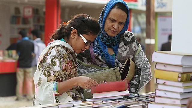 অমর একুশে গ্রন্থমেলার চতুর্থ দিন আজ। মেলার একটি স্টলে বই দেখছেন দুই পাঠক। ছবি : আবদুস সালাম