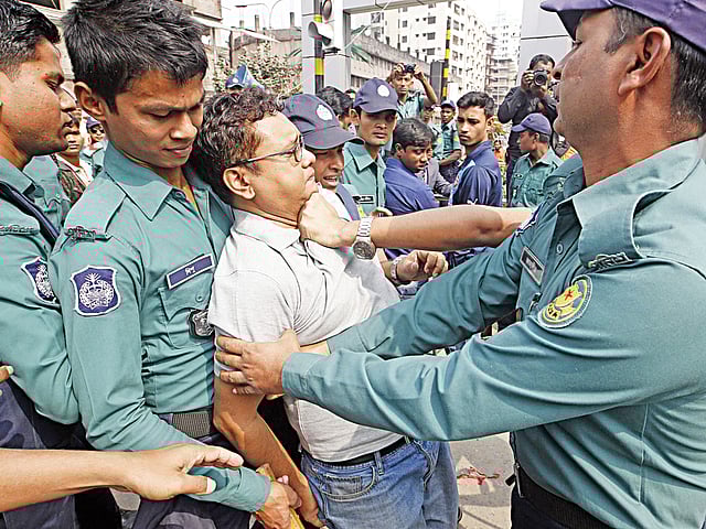 পদচারী-সেতু ব্যবহার না করে রাস্তা পার হওয়ায় আমিনুল ইসলাম নামের এই ব্যক্তিকে জরিমানা করেন ভ্রাম্যমাণ আদালত।  এই নিয়ে বাগ্‌বিতণ্ডার একপর্যায়ে প্রকাশ্যে পুলিশ সদস্যদের হাতে হেনস্তার শিকার হন তিনি। ছবিটি রাজধানীর বাংলামোটর মোড় থেকে গতকাল বেলা সাড়ে ১১টার দিকে তোলা l সাজিদ হোসেন