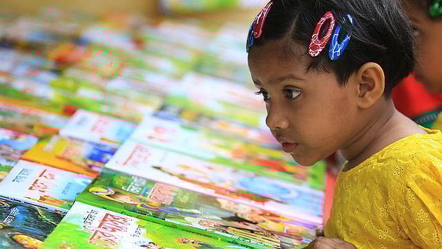 স্টলে পছন্দের বই দেখছে শিশুটি। ছবি: আশরাফুল আলম