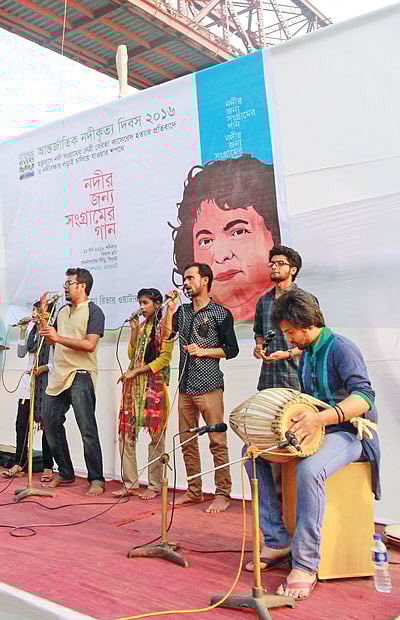 সিলেট নগরের কিনব্রিজ এলাকায় সুরমা নদীর চাঁদনিঘাটে গতকাল ‘নদীর জন্য সংগ্রামের গান’ পরিবেশন করেন নগরনাটের শিল্পীরা l ছবি: প্রথম আলো