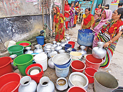 অনেক এলাকাতেই রয়েছে পানির তীব্র সংকট। হাজারীবাগ বেড়িবাঁধ এলাকার ভাগলপুরের বাসিন্দারা দিনের পর দিন লাইন ধরে পানির অপেক্ষায় থাকেন। ছবিটি গতকাল দুপুরের l প্রথম আলো