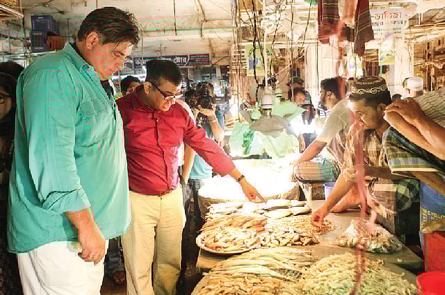 ঢাকার একটি কঁাচাবাজারে ম্যাট প্রেস্টন (বাঁয়ে), সঙ্গে উপস্থাপক নাভীদ মাহবুব