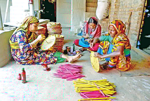 মেয়ে ও ছেলের স্ত্রীকে নিয়ে পাখা তৈরির কাজ করছেন হাজেরা বিবি (ডানে)। ছবিটি বগুড়ার কাহালু উপজেলার পাইকড় ইউনিয়নের আতালপাড়া গ্রাম থেকে সম্প্রতি তোলা l ছবি: প্রথম আলো