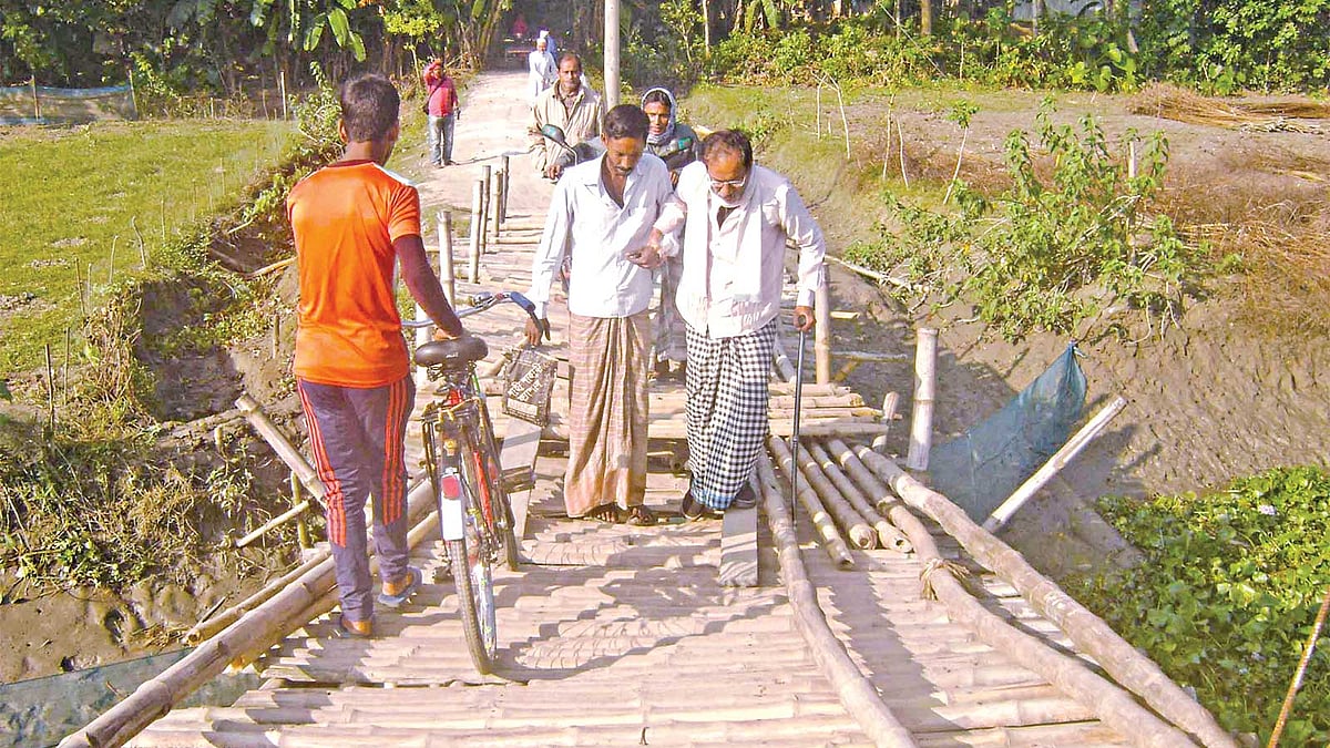 সংস্কারের অভাবে নড়াইল সদর উপজেলার শেখহাটি ইউনিয়নের আফরা এলাকায় বুড়ি ভৈরব নদীর ওপরে বাঁশ ও কাঠের তৈরি সাঁকোটির পাটাতন ভেঙে ঝুঁকিপূর্ণ হয়ে গেছে। সম্প্রতি তোলা ছবি l প্রথম আলো