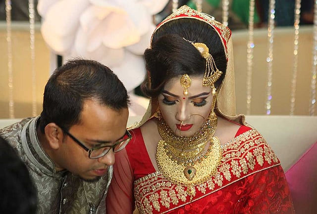 কিছু একটা নিয়ে নিজেদের মধ্যে কথা বলছেন বর-কনে। ছবি: খালেদ সরকার