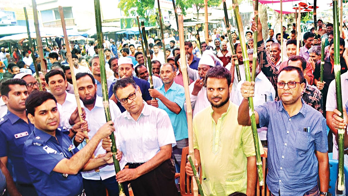 ‘টার্গেট কিলিং’সহ সন্ত্রাস প্রতিরোধে সাধারণ মানুষকে সম্পৃক্ত করতে চুয়াডাঙ্গায় লাঠি-বাঁশি কর্মসূচি। গতকাল বিকেলে সদর উপজেলার সরোজগঞ্জ বাজারে জেলা পুলিশের উদ্যোগে সচেতনতামূলক সভা শেষে উপস্থিত জনতার মধ্যে লাঠি ও বাঁশি বিতরণ করেন পুলিশ সুপার মো. রশীদুল হাসান l ছবি: প্রথম আলো