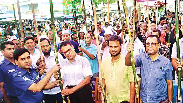 ‘টার্গেট কিলিং’সহ সন্ত্রাস প্রতিরোধে সাধারণ মানুষকে সম্পৃক্ত করতে চুয়াডাঙ্গায় লাঠি-বাঁশি কর্মসূচি। গতকাল বিকেলে সদর উপজেলার সরোজগঞ্জ বাজারে জেলা পুলিশের উদ্যোগে সচেতনতামূলক সভা শেষে উপস্থিত জনতার মধ্যে লাঠি ও বাঁশি বিতরণ করেন পুলিশ সুপার মো. রশীদুল হাসান l ছবি: প্রথম আলো
