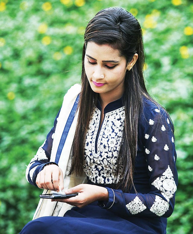 টিস্যু বা নরম কাপড় দিয়ে মুছতে পারেন ফোনের পর্দা। ​মডেল: অপর্ণা, ছবি: খালেদ সরকার