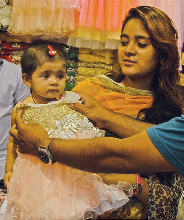 শিশুর পোশাক বাছাইয়ে ব্যস্ত মা। ছবিটি গত মঙ্গলবার নগরের আফমি প্লাজা থেকে তোলা l জুয়েল শীল