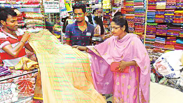 ফেনী শহরের গ্র্যান্ড হক টাওয়ারে পোশাক বাছাইয়ে ব্যস্ত এক  নারী l প্রথম আলো
