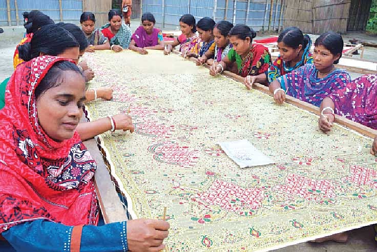 তারাগঞ্জের জিগারতলা গ্রামে ‘হতদরিদ্র কর্মজীবী মহিলা উন্নয়ন সমিতির’ সদস্যদের সঙ্গে শাড়িতে নকশা তোলার কাজ করছেন শিল্পী বেগম l ছবি: প্রথম আলো