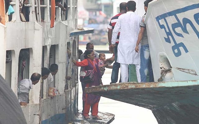 ঝুঁকি নিয়ে শিশুসহ লঞ্চে উঠছেন একজন। ছবি: আবদুস সালাম