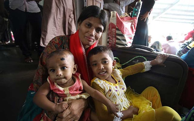 লঞ্চের মেঝেতে দুই শিশু নিয়ে বসার জায়গা পেয়েই খুশি এই যাত্রী। ছবি: আবদুস সালাম