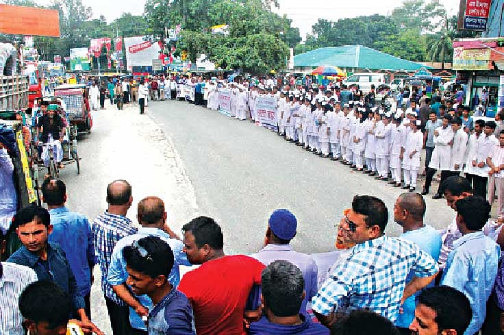 দেশব্যাপী জঙ্গি ও সন্ত্রাসী হামলার প্রতিবাদে গতকাল স্বাধীনতা চিকিৎসক পরিষদ রংপুর নগরের মেডিকেল মোড়ে মহাসড়কের কাছে মানববন্ধন করে। এতে রংপুর মেডিকেল কলেজ ও হাসপাতালের শিক্ষক–শিক্ষার্থী, চিকিৎসক ও কর্মকর্তা–কর্মচারীরা অংশ নেন l ছবি: প্রথম আলো