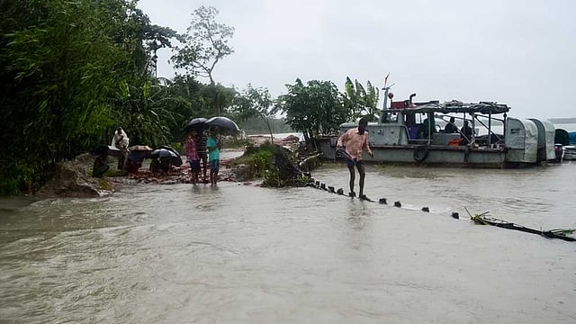 বরিশালের চরবাড়িয়া ইউনিয়নের মধ্য চরবাড়িয়া অংশে বাঁধ ভেঙে আড়িয়াল খাঁ নদের পানি প্রবেশ করছে কীর্তনখোলা নদীতে। বাঁধ ভেঙে যাওয়া ও জোয়ারের পানি প্রবেশের কারণে ওই ইউনিয়নের মানুষের চলাচল ঝুঁকিপূর্ণ হয়ে উঠেছে। কিছু মানুষ জীবনের তাগিদে নদীর পাশের বাঁধের ওপর দিয়ে ঝুঁকি নিয়ে চলাচল করছে। ছবিটি গতকাল মঙ্গলবার সকালে তোলা। ছবি: সাইয়ান