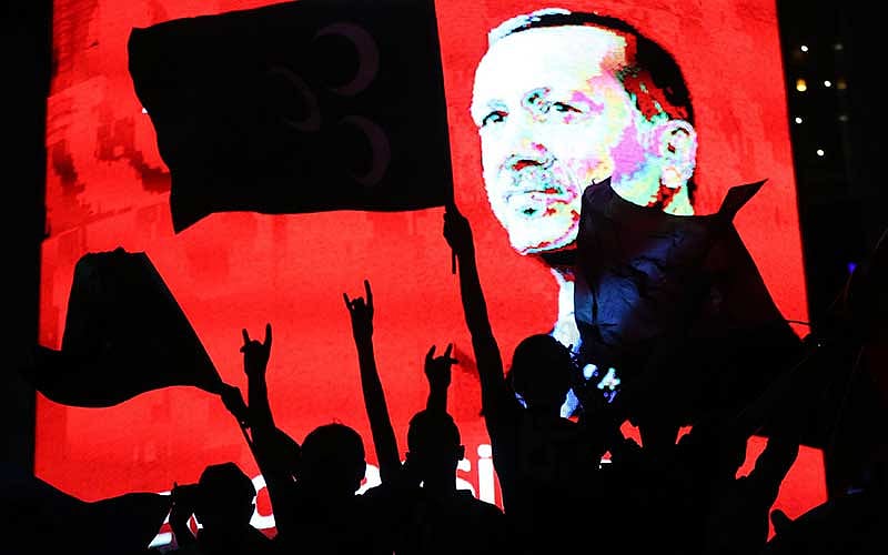 সেনা অভ্যুত্থান ব্যর্থ করে দেওয়ার পর তুরস্কের প্রেসিডেন্ট রিসেপ তাইয়েপ এরদোয়ানের ছবির সামনে সমর্থকদের উল্লাস। ছবি: এএফপি