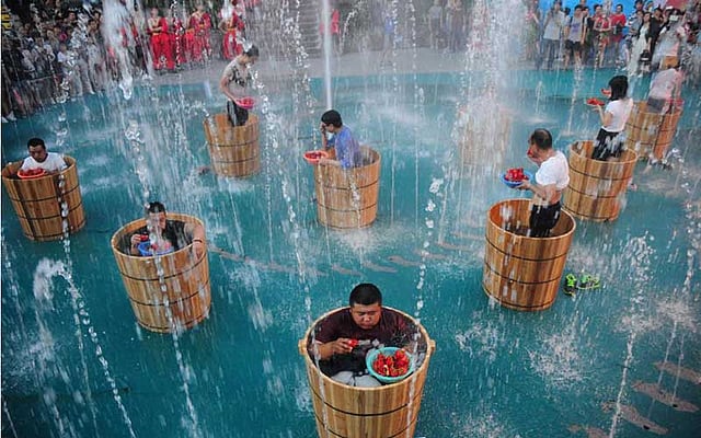 চীনের ঝেজিয়াং প্রদেশে গতকাল বৃহস্পতিবার লঙ্কা খাওয়ার প্রতিযোগিতার সময় বরফে গোসল করছেন প্রতিযোগীরা। ছবি: রয়টার্স