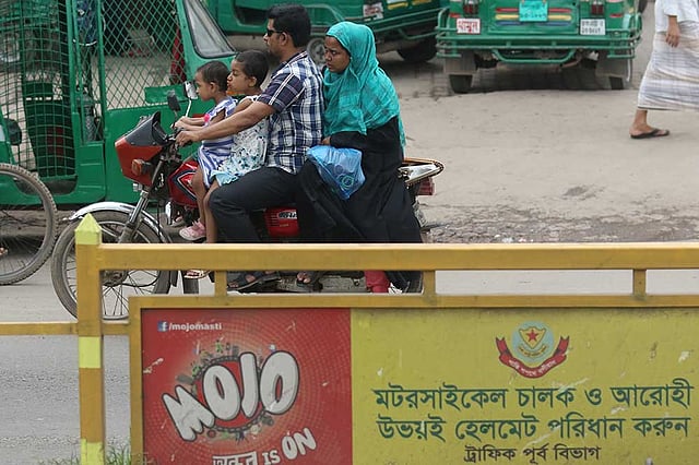 অনেকেই ট্রাফিক আইন ভেঙে হেলমেট ছাড়াই মোটরসাইকেল চালান। আইনের কথা বিভিন্ন জায়গায় লেখা থাকে, কিন্তু বাস্তবায়ন হয় না। ছবিটি আজ শুক্রবার সকালে রাজধানীর মুগদাপাড়া বাসস্ট্যান্ড এলাকা থেকে তোলা। ছবি: আবদুস সালাম