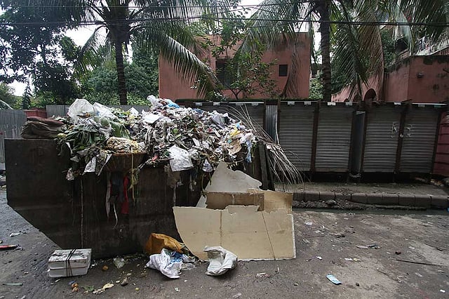 রাজধানীর আহসান মঞ্জিলের সীমানাপ্রাচীর ঘেঁষে গড়ে উঠেছে ময়লার ভাগাড় ও কাপড়ের দোকান। ছবিটি আজ শুক্রবার দুপুরে ইসলামপুরের আহসানউল্লাহ রোড থেকে তোলা। ছবি: আবদুস সালাম