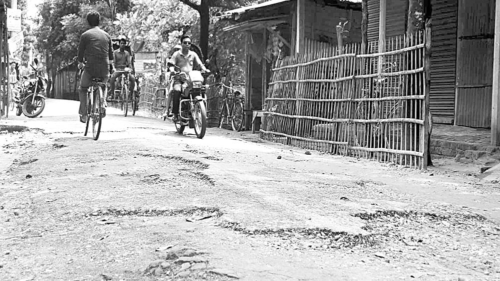ঠাকুরগাঁও পৌর এলাকার রাস্তাগুলোর কার্পেটিং ও ইট-খোয়া উঠে ছোট-বড় গর্তের সৃষ্টি হয়েছে। এসব সড়ক দিয়ে চলাচল করতে গিয়ে ভোগান্তি পোহাতে হচ্ছে পৌরবাসীকে। ছবিটি গতকাল সকালে সিরাজদৌল্লা সড়ক থেকে তোলা l প্রথম আলো