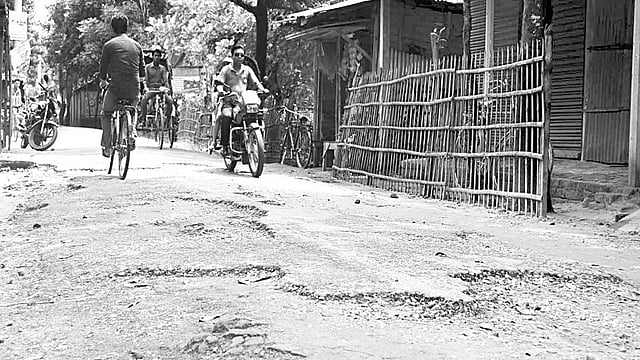 ঠাকুরগাঁও পৌর এলাকার রাস্তাগুলোর কার্পেটিং ও ইট-খোয়া উঠে ছোট-বড় গর্তের সৃষ্টি হয়েছে। এসব সড়ক দিয়ে চলাচল করতে গিয়ে ভোগান্তি পোহাতে হচ্ছে পৌরবাসীকে। ছবিটি গতকাল সকালে সিরাজদৌল্লা সড়ক থেকে তোলা l প্রথম আলো