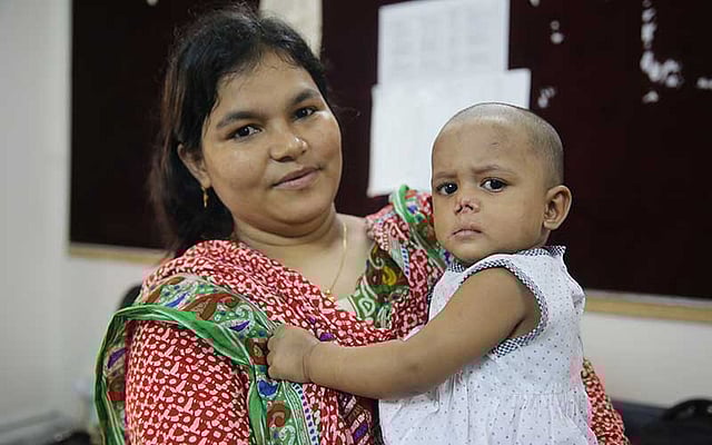 নিবাসের সেবিকা আনোয়ারা বেগমের কোলে ফাইজা। ছবি: জাহিদুল করিম