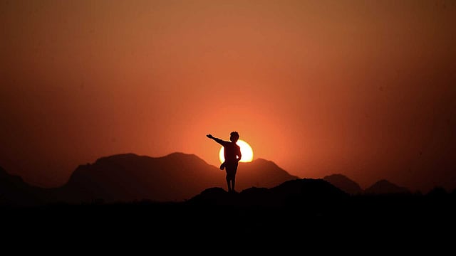 সূর্য যাচ্ছে পাটে। এরই পটভূমিতে এক আফগান তরুণ। ছবিটি সম্প্রতি আফগানিস্তানের হেরাত প্রদেশের শহরতলি থেকে তোলা। ছবি: এএফপি