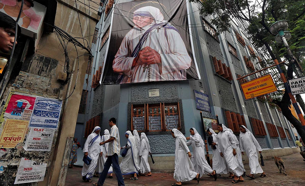 আর্তমানবতার সেবক প্রয়াত মাদার তেরেসাকে আজ রোববার সন্ত (সেইন্ট) হিসেবে ঘোষণা দেবে ভ্যাটিকানের রোমান ক্যাথলিক চার্চ। কলকাতায় মিশনারিজ অব চ্যারিটিতে তাঁর ছবির সামনে দিয়ে যাচ্ছেন কয়েকজন নান। ছবি: রয়টার্স