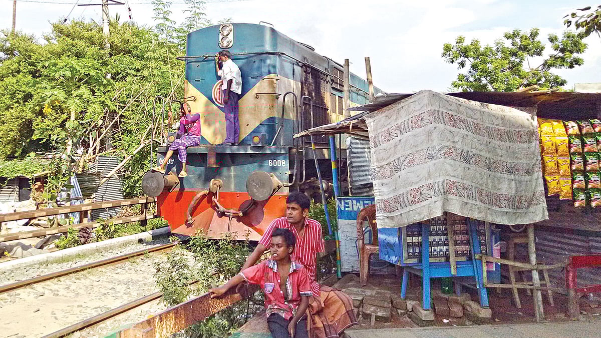 রাজশাহীতে রেললাইনের পাশ ঘেঁষে গড়ে ওঠা বাড়িঘর ও দোকানপাট। ছবিটি গতকাল নগরের আইডি হাসপাতাল কলাবাগান এলাকা থেকে তোলা l প্রথম আলো