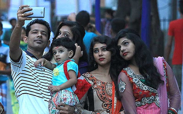 দুর্গাপূজা উপলক্ষে ঘুরতে বেরিয়ে সেলফি তুলছে এক হিন্দু পরিবার। ছবিটি আজ সোমবার ঢাকেশ্বরী মন্দির এলাকা থেকে তোলা। ছবি: আশরাফুল আলম