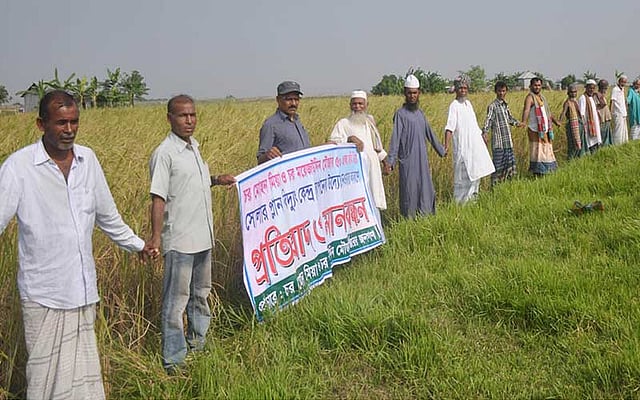 জমি রক্ষায় ধানখেতে মানববন্ধন। ফরিদপুরের চরভদ্রাসন উপজেলার গাজীরটেক ইউনিয়নের চর মোহন মিয়া ও চর মৈজদ্দিন মৌজার ৫০০ একর জমি অধিগ্রহণ করে সৌরবিদ্যুৎকেন্দ্র স্থাপনের প্রতিবাদ এবং প্ল্যান্টটি অন্যত্র সরানোর দাবিতে চরবাসীদের এই মানববন্ধন। ছবিটি গতকাল শুক্রবার বিকেলে তোলা। ছবি: পান্না বালা