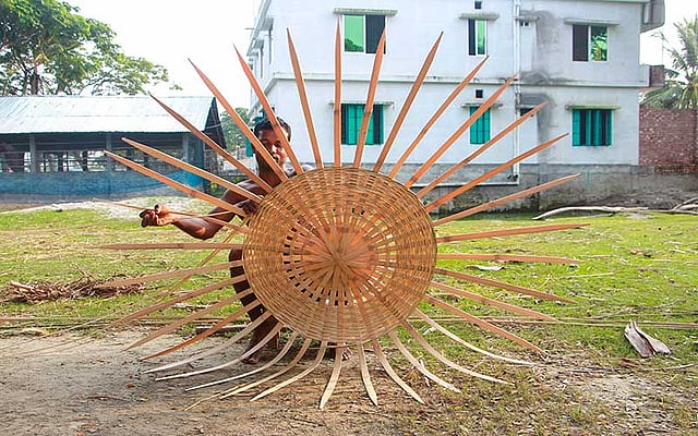 কাঁচা বাঁশের চিকন চাটাই দিয়ে মুরগির খাঁচা তৈরি করছেন শিবু। খাঁচাটি তিনি চার শ টাকায় বিক্রি করবেন। ছবিটি গতকাল শুক্রবার খুলনার রূপসা উপজেলার জাবুসা থেকে বিকেলে তোলা। ছবি: সাদ্দাম হোসেন