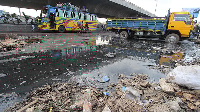 ঢাকা-চট্টগ্রাম মহাসড়কের দক্ষিণ যাত্রাবাড়ীর অংশ নোংরা পানি ও আবর্জনায় সয়লাব। অন্যদিকে পিকআপ ভ্যানের স্ট্যান্ড। সংকুচিত হয়ে পড়েছে সড়কটি। ছবিটি শনিবার দুপুরে তোলা। ছবি: আবদুস সালাম