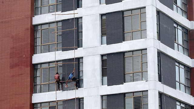 সুউচ্চ ভবনে কোনো রকম নিরাপত্তা ছাড়াই রশিতে ঝুলে কাজ করছেন দুই শ্রমিক৷ নেই হেলমেট বা সেফটি জ্যাকেট ৷ ছবিটি শনিবার সকালে রাজধানীর আগারগাঁও এলাকা থেকে তোলা৷ ছবি: সাবিনা ইয়াসমিন
