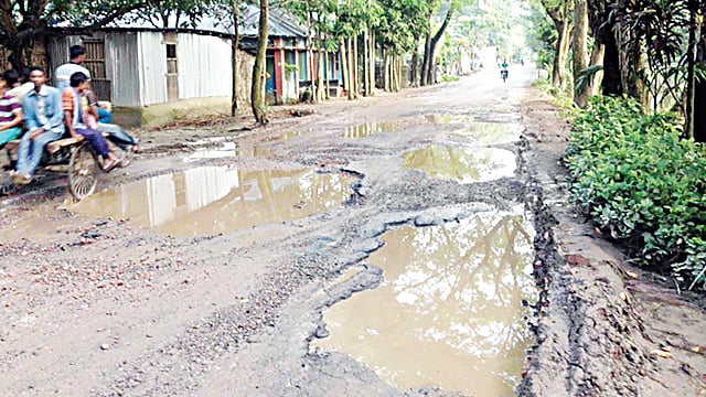 নাটোরের লালপুর-বনপাড়া সড়কের বিভিন্ন স্থানে গর্ত তৈরি হয়েছে। এতে সড়কটি যানবাহন চলাচলের অনুপযোগী হয়ে পড়েছে। লালপুরের চকনাজিরপুর এলাকা থেকে গত শুক্রবার তোলা ছবি l প্রথম আলো
