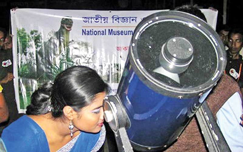 টেলিস্কোপের সাহায্যে আকাশ দেখছেন এক দর্শনার্থী l প্রথম আলো
