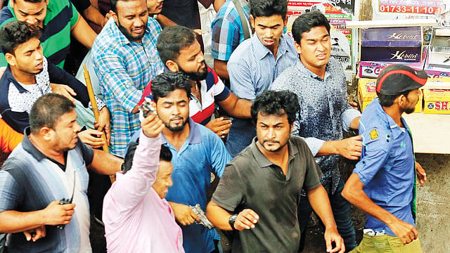 গুলিস্তানে ডিএসসিসির উচ্ছেদ অভিযান চলার সময় হকারদের অস্ত্র হাতে ধাওয়া করেন একদল যুবক। (বাঁয়ে) হাতে অস্ত্র উঁচিয়ে ছাত্রলীগের ঢাকা মহানগর দক্ষিণের সাধারণ সম্পাদক সাব্বির হোসেন (গোলাপি জামা গায়ে) এবং পাশে অস্ত্র হাতে ছাত্রলীগের ওয়ারী থানা শাখার সাধারণ সম্পাদক আশিকুর রহমান l ছবি: প্রথম আলো