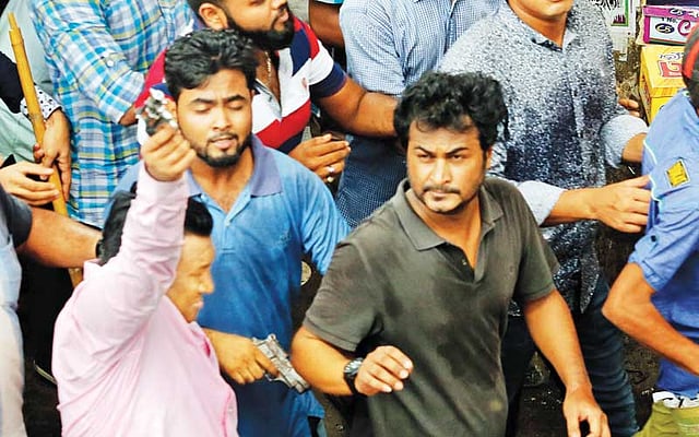গুলিস্তানে ডিএসসিসির উচ্ছেদ অভিযান চলার সময় অস্ত্র হাতে হকারদের ধাওয়া করেন সাব্বির হোসেন (বাঁয়ে) এবং আশিকুর রহমান  l ফাইল ছবি