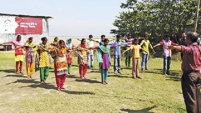 রাজশাহীর চরখিদিরপুরে আলোর পাঠশালায় শরীরচর্চা করছে ছেলেমেয়েরা। ছবি: সহিদুল ইসলাম
