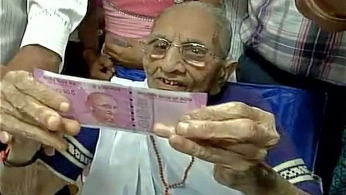 রুপি হাতে ভারতের প্রধানমন্ত্রীর মা হীরাবেন। ছবি: সংগৃহীত