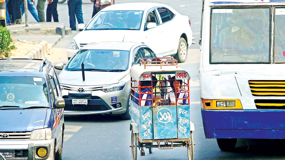 বিপরীত দিক থেকে ছুটে আসছে যানবাহন। ডানে গাড়ি, বাঁয়েও গাড়ি। সেসবের তোয়াক্কা না করেই শিশুদের নিয়ে ছুটে চলেছেন ভ্যানচালক। ছবিটি গতকাল দুপুরে রাজধানীর উইলস লিটল ফ্লাওয়ার স্কুলের সামনে থেকে তোলা l প্রথম আলো