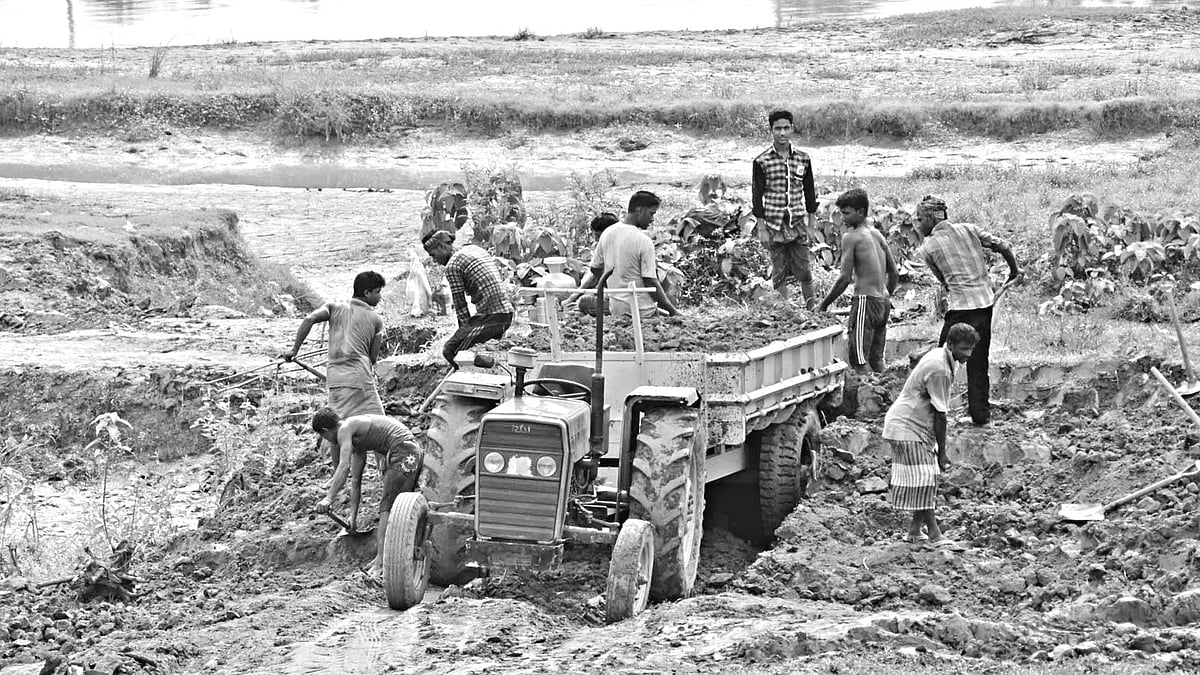 কুমিল্লার গোমতী নদী থেকে মাটি কেটে ট্রাকে তোলা হচ্ছে। বুড়িচং উপজেলার গোবিন্দপুর এলাকা থেকে সম্প্রতি তোলা ছবি l প্রথম আলো