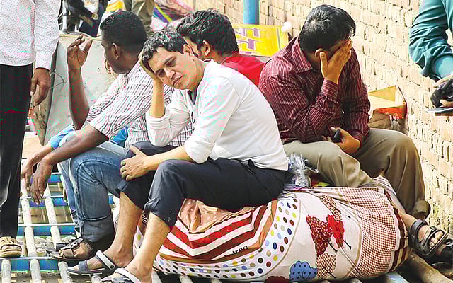 গুলশান ডিএনসিসি মার্কেটে গত সোমবার দিবাগত রাতের আগুনে সব হারিয়ে নিঃস্ব ব্যবসায়ীরা বসে আছেন পথে l ছবি: প্রথম আলো