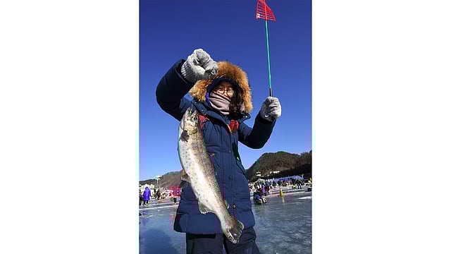 মাছ শিকার করতে পেরে বিজয়ের হাসি। ছবি: এএফপি