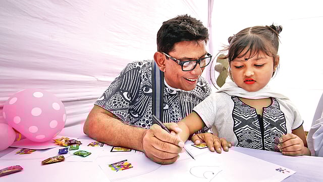 ২০১৬ সালে প্রথম আলোর বর্ণমেলায় অভিনেতা ও শিল্পী আফজাল হোসেনের কাছ থেকে হাতেখড়ি নিচ্ছে এক শিশু। ছবি: প্রথম আলো