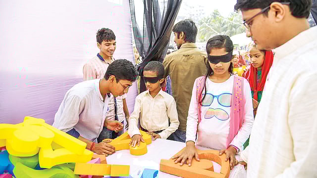 চট্টগ্রামের বর্ণমেলায় চোখ বে​ঁধে স্পর্শ করে বর্ণ চেনার খেলায় মেতে ওঠে শিশুরা