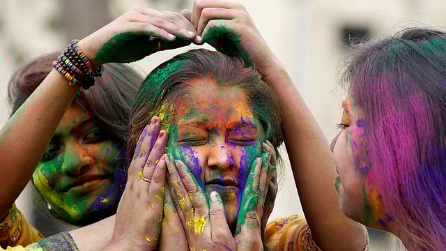 হোলি উপলক্ষে মুখে রং মাখাচ্ছেন তরুণীরা। ছবিটি আজ শুক্রবার ভারতের আগরতলা থেকে তোলা। ছবি: রয়টার্স