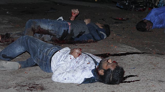 দুই দফা বোমা বিস্ফোরণে আহত দুজন সড়কের ওপর রক্তাক্ত অবস্থায় পড়ে আছেন। ছবি: আনিস মাহমুদ