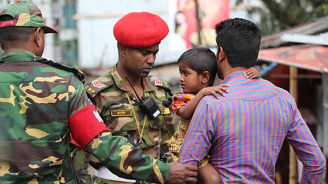 সিলেট সন্দেহভাজন জঙ্গি আস্তানা আতিয়া মহলে আটকে পড়া এক শিশুকে উদ্ধার করে নিয়ে যাওয়া হচ্ছে। ছবি: আনিস মাহমুদ